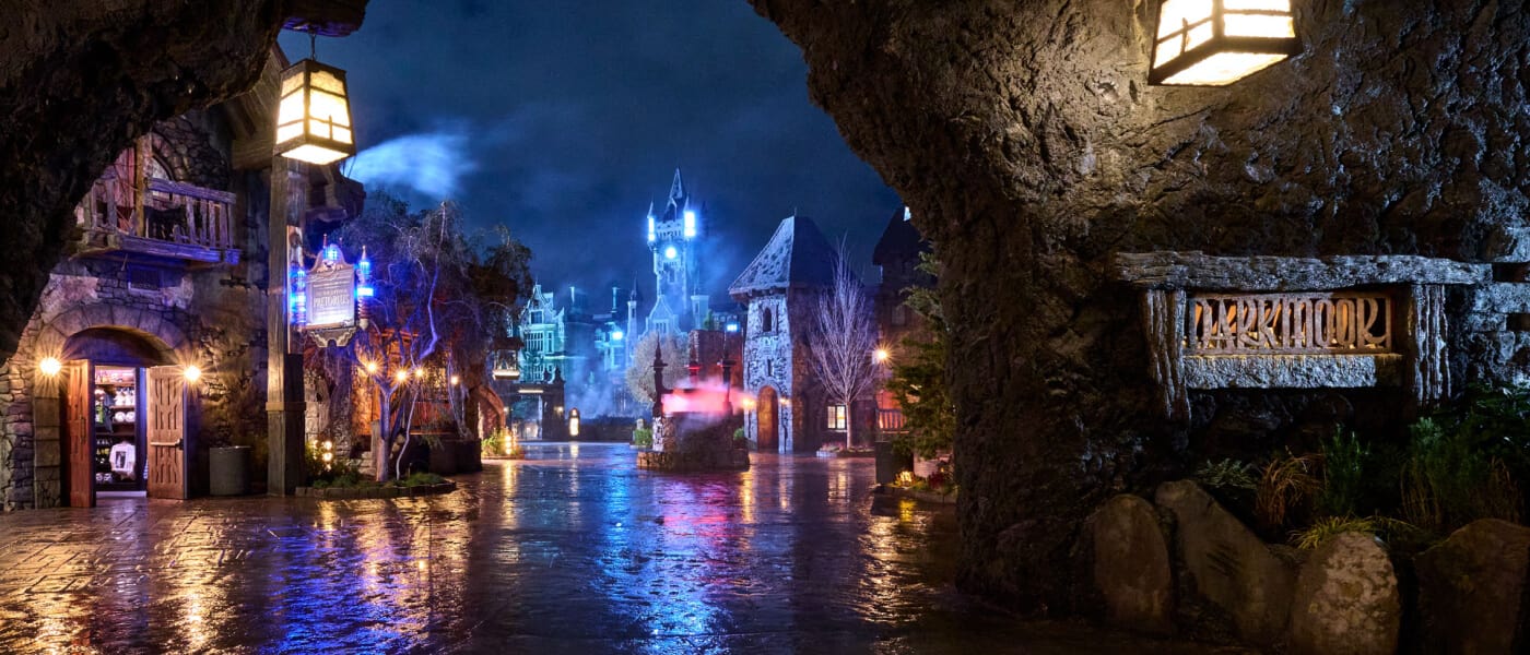 A view of Darkmoor Village, with building lights aglow against the ominous night sky.