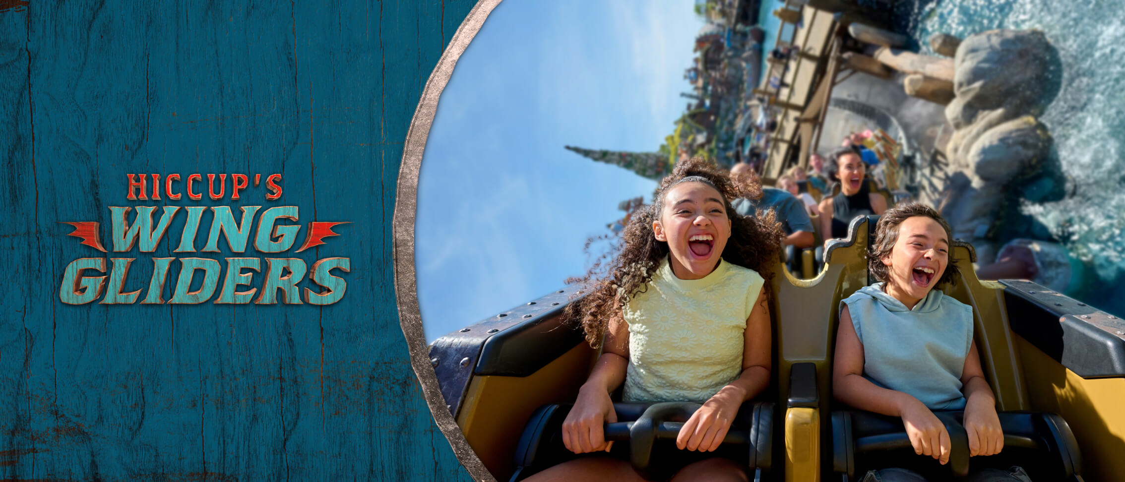Two excited kids laughing as their coaster vehicle skims over the water with the Isle of Berk mountain in the background.
