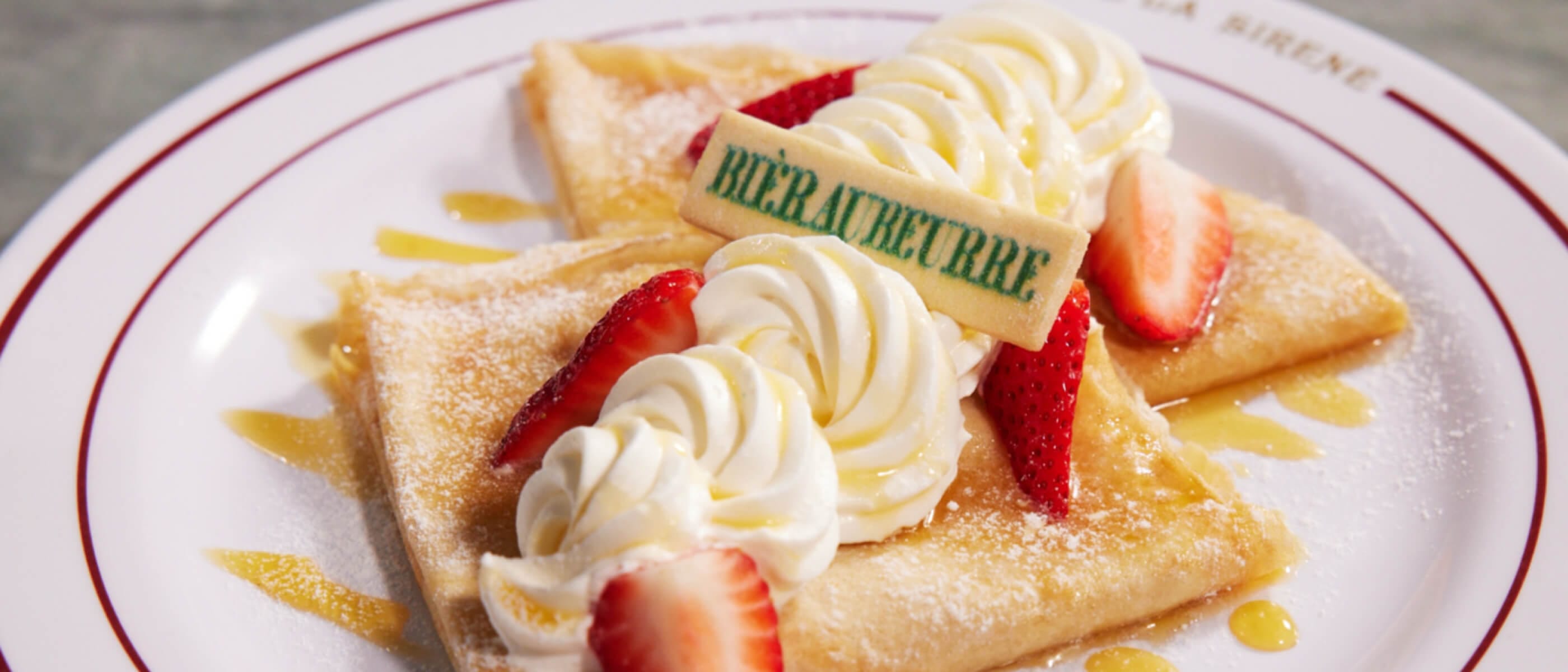 Butterbeer™ Crepe filled with shortbread cookie butter Bavarian cream, Butterbeer™ cream, strawberries and topped with a Butterbeer™ drizzle and a Butterbeer™ shortbread cookie served at Café Lair De La Sirène
