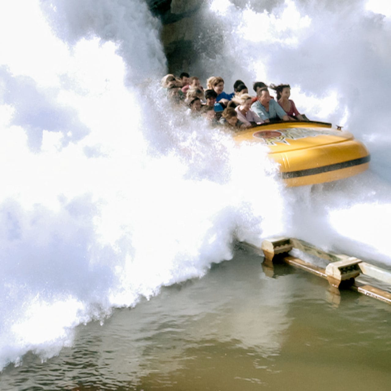 Riders get soaked as they make a huge splash at the end of Jurassic Park River Adventure.