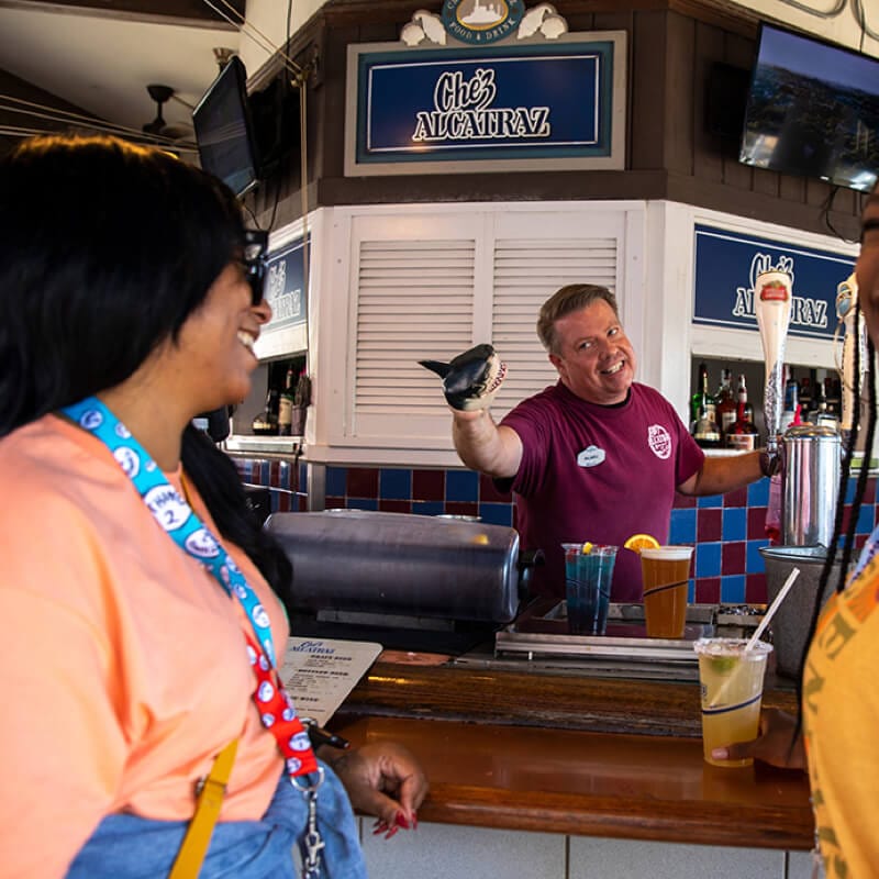Guests laughing as they interact with the bartender.
