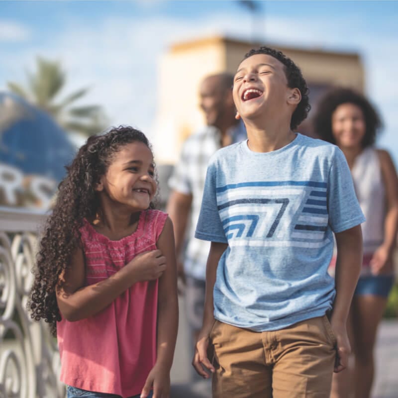 Two children laugh as they stroll at Universal Orlando Resort.