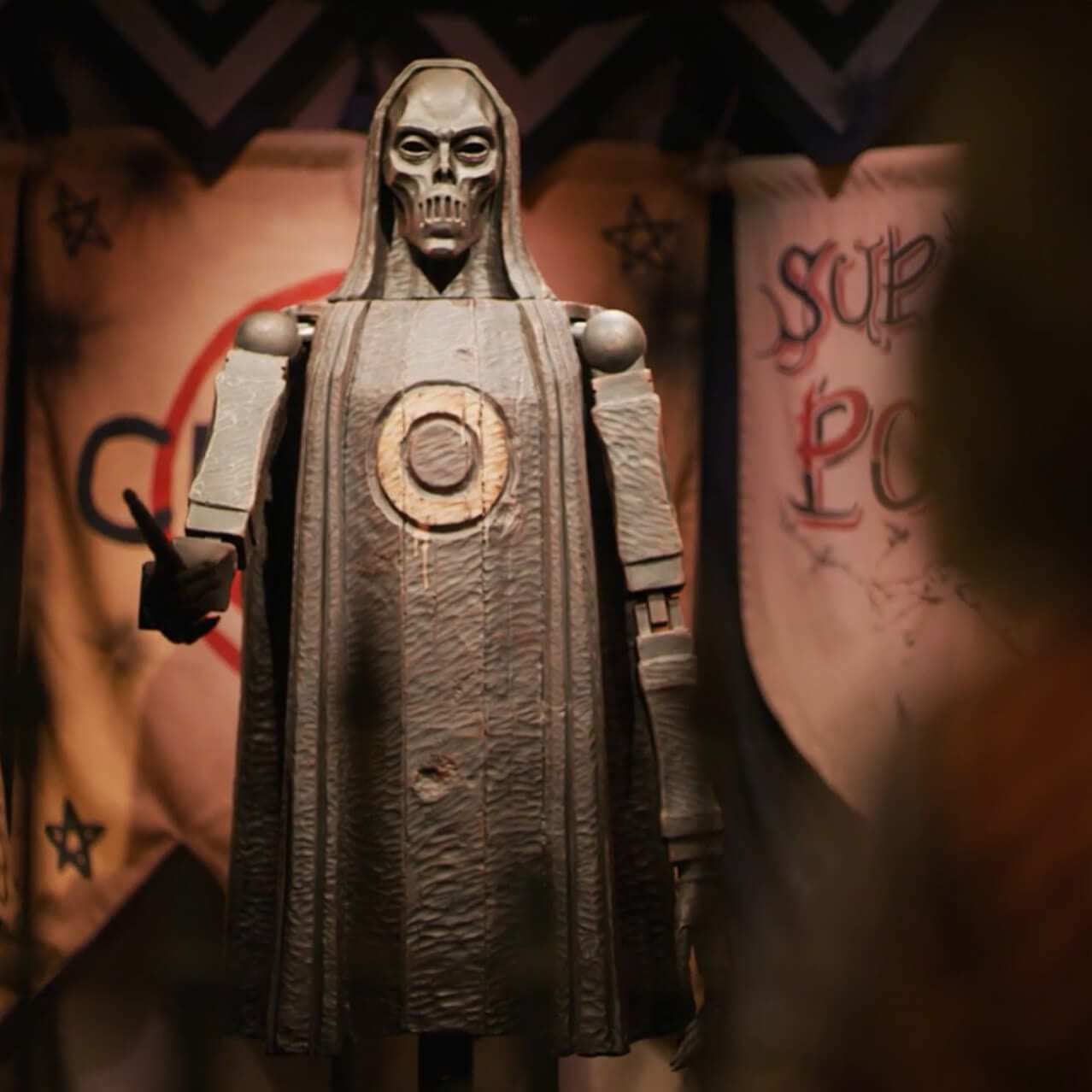 A guest raises a wand as they prepare to duel with a sinister figure.