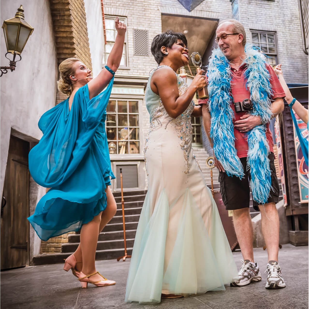Celestina Warbeck and the Banshees interact with a guest wearing a feathered boa in Diagon Alley at Universal Studios Orlando.