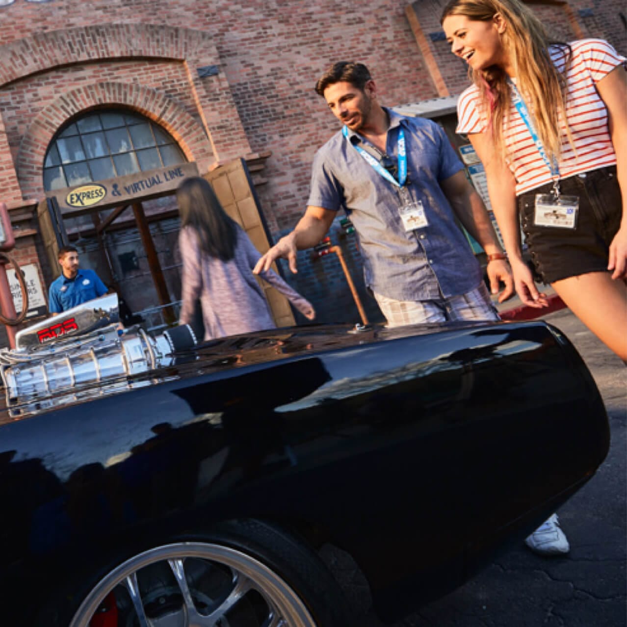 Guests admire a muscle car on display.