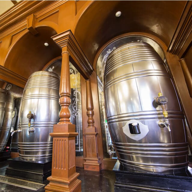 Interior shot of The Fountain of Fair Fortune in The Wizarding World of Harry Potter at Universal Studios Orlando showing giant kegs of beer.