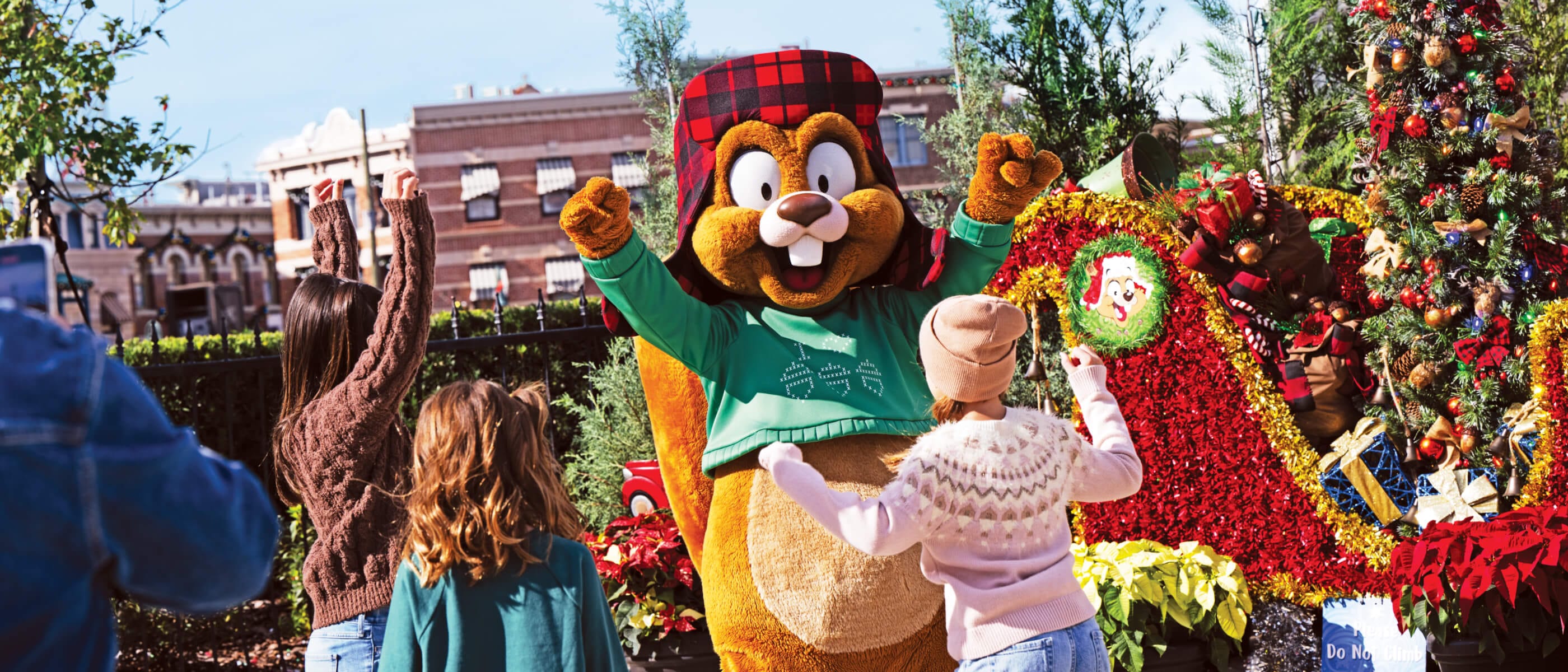 Kids dance and cheer on Earl the Squirrel alongside a festive tree at Universal Studios Florida.