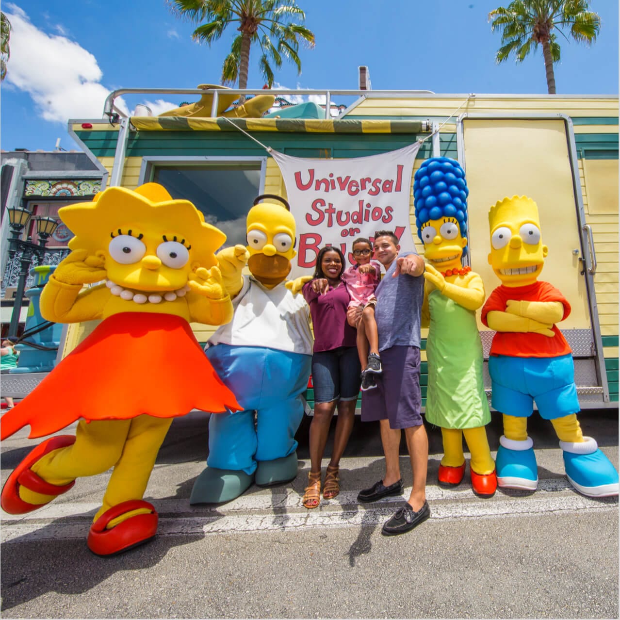 Simpsons characters pose with a man, woman, and child in the Hollywood Character Zone at Universal Studios Orlando.