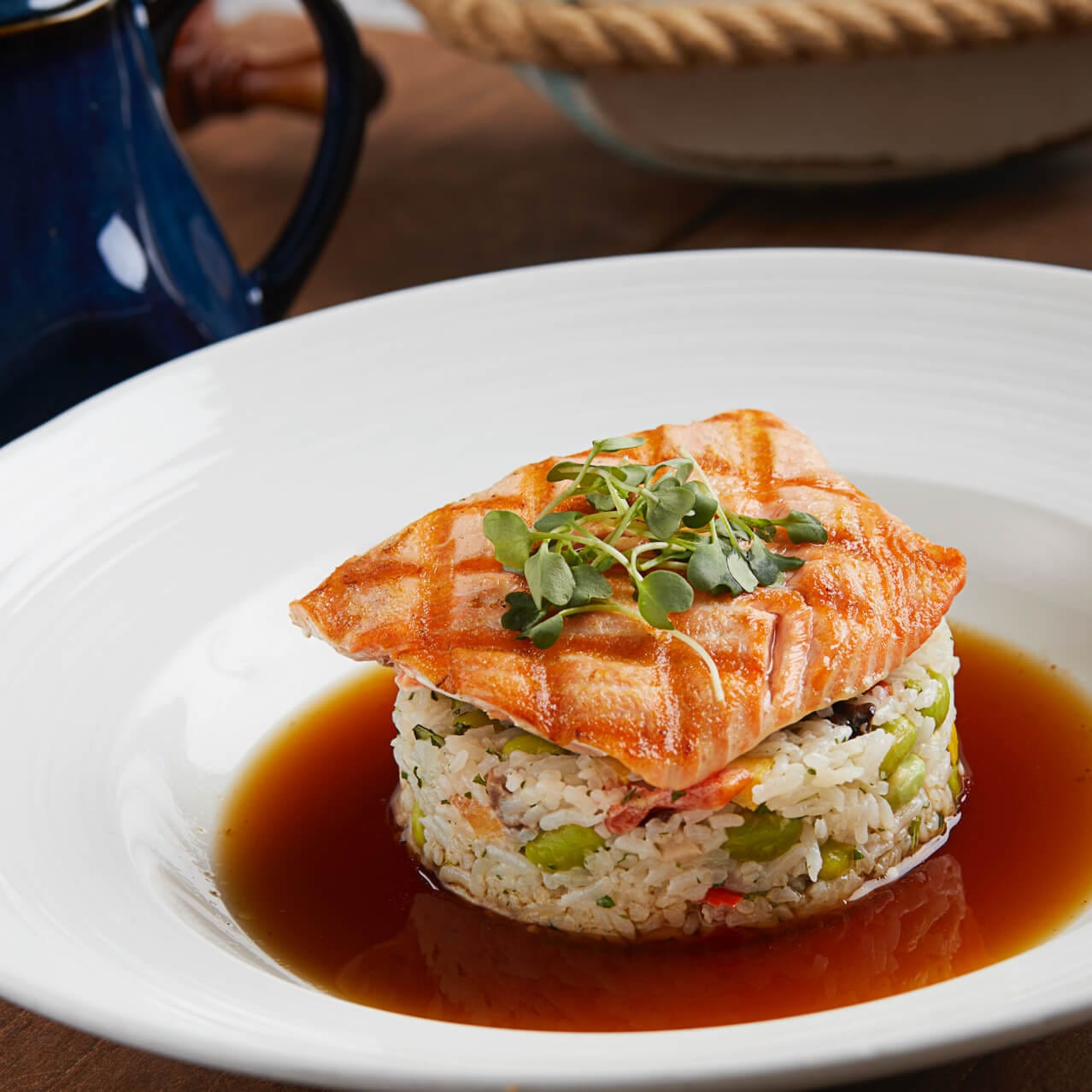 A plate of delicious salmon over an Edamame succotash, jasmine rice, miso broth and crisp parsnips available at Lombard's Seafood Grille in Universal Studios Orlando.