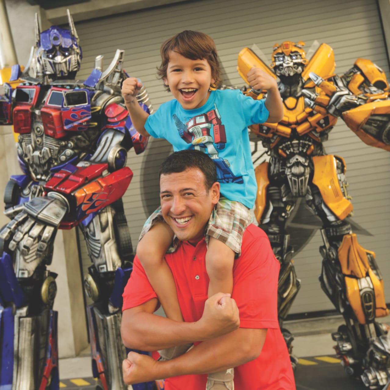 Father and son take a picture with Bumblebee and Optimus Prime at Meet The TRANSFORMERS in Universal Studios Florida.
