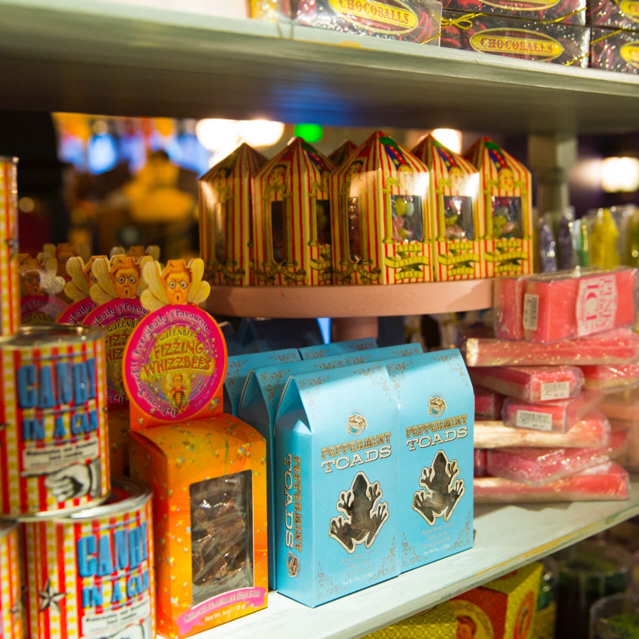Treats like Peppermint Toads and Fizzing Whizzbees displayed on shelves inside Sugarplum's Sweet Shop at Universal Studios Florida.