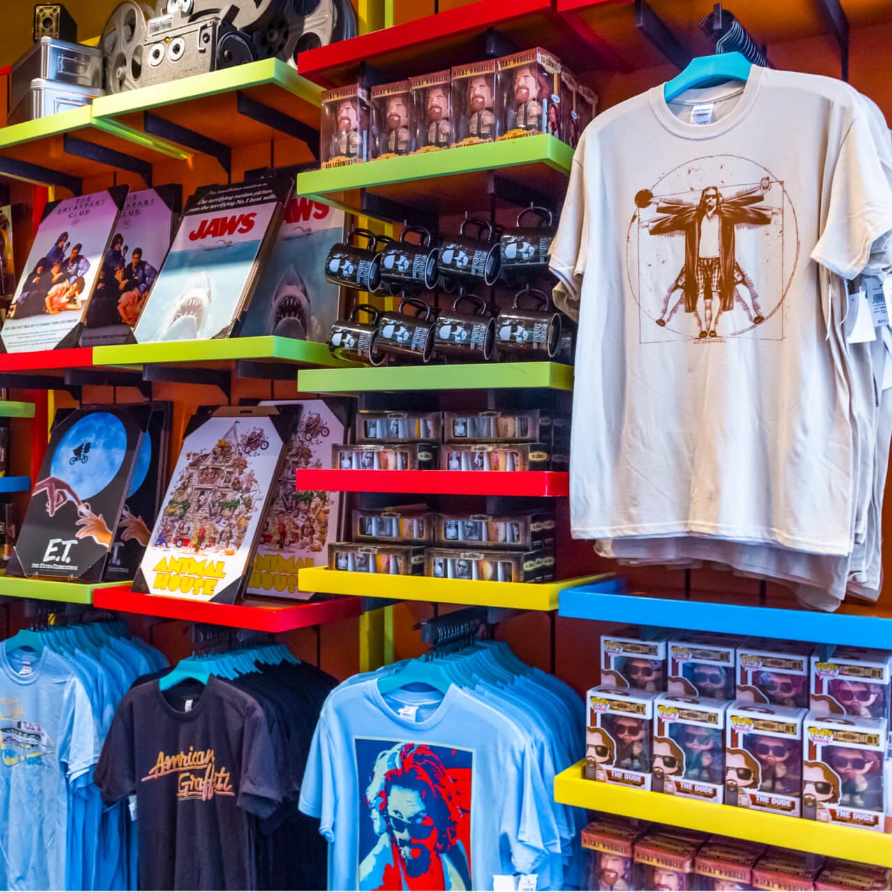 Movie poster inspired artwork and mugs on display in The Film Vault, a shop in Universal Studios Orlando.