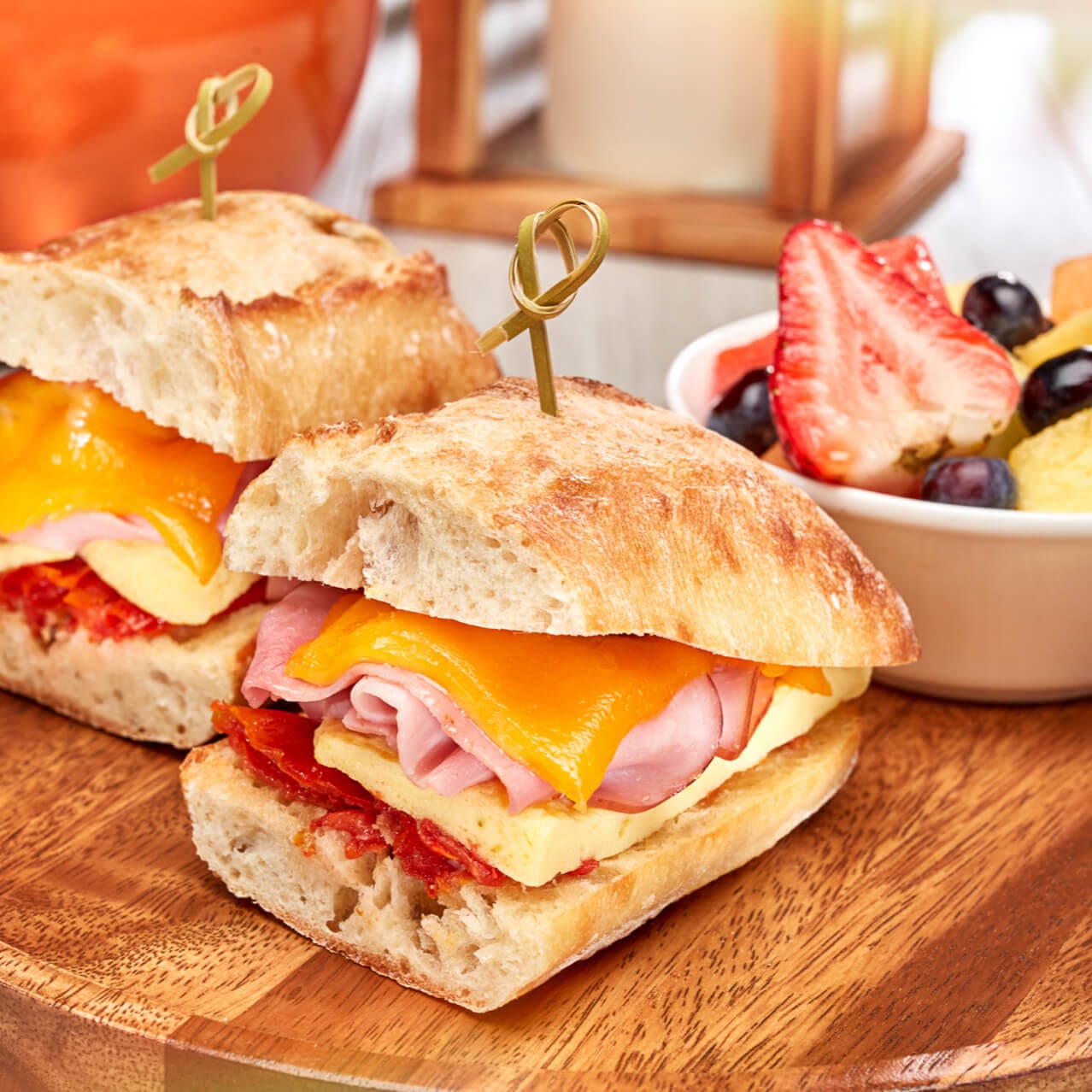 Ham, Egg & Cheese breakfast sandwich from TODAY Cafe served with fresh fruit.