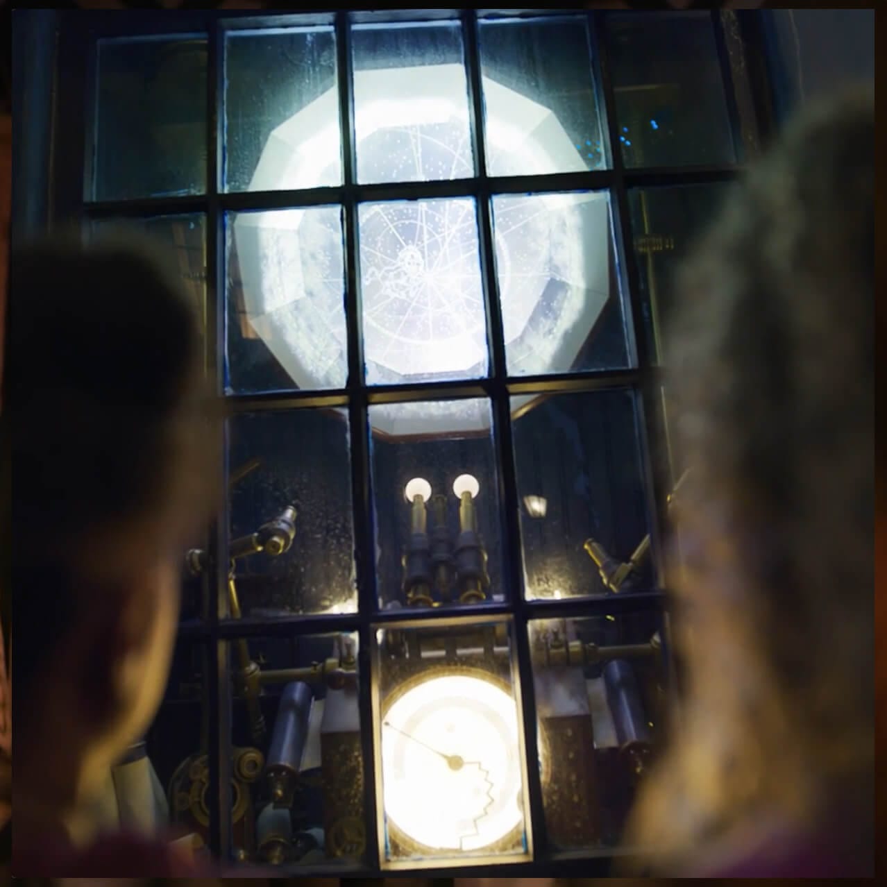 A guest pointing a wand at a shop window where a large multi-sided object hovers and glows.
