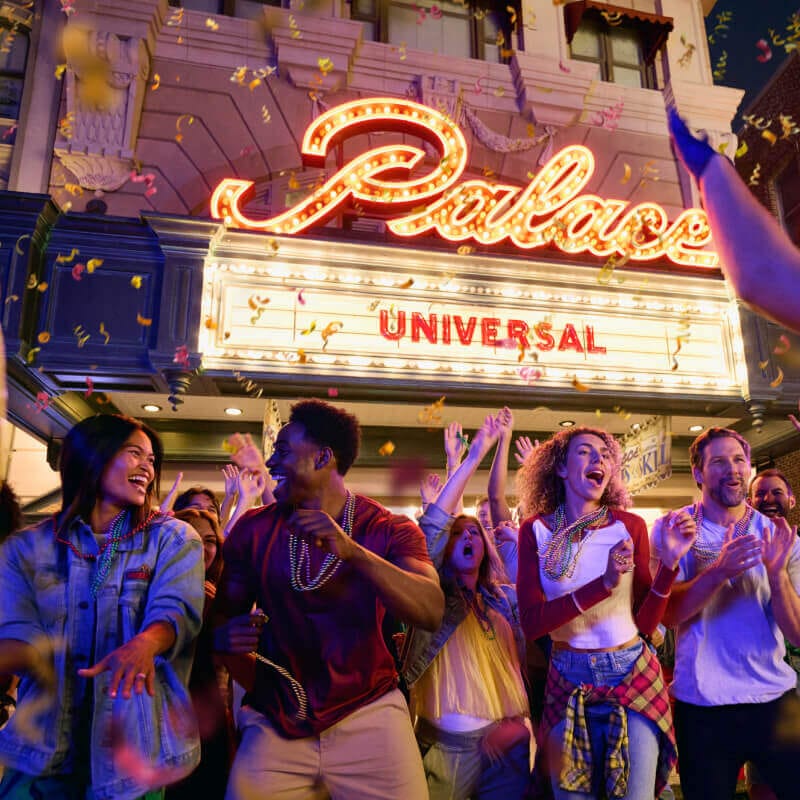 Guests dancing and laughing while watching the parade at Universal Mardi Gras: International Flavors of Carnival.