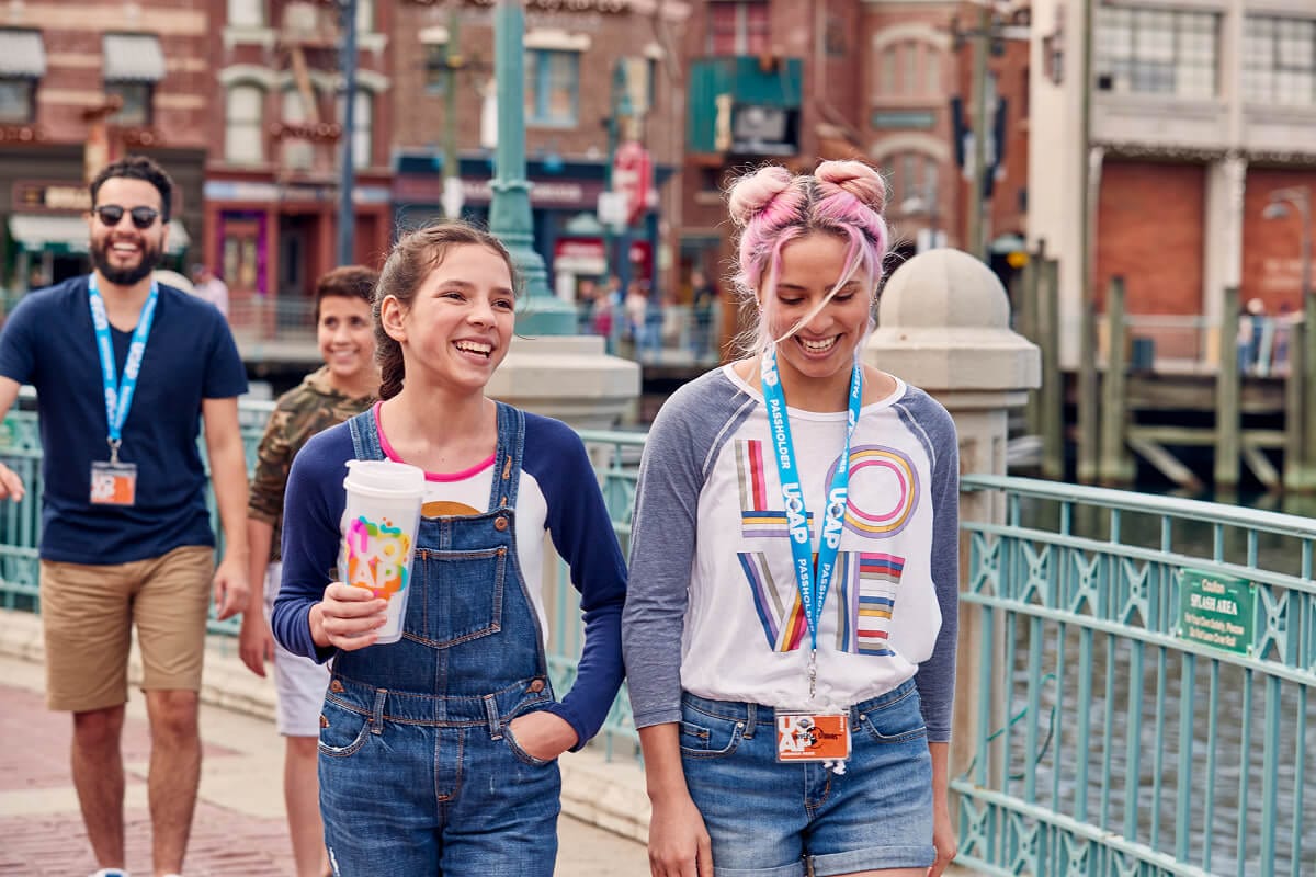 Four Universal Orlando Annual Passholders walking through Universal Studios Florida while one is holding an AP Exclusive Coca-Cola Freestyle® Souvenir Cup