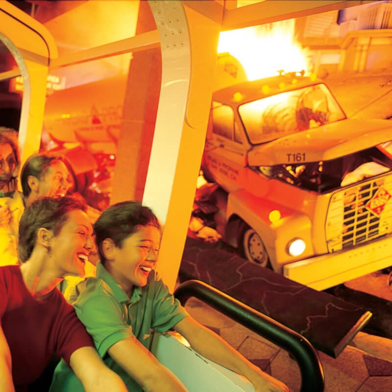 Guests riding a subway car laugh and scream as they go through a simulated disaster, complete with flaming cars, floods and earthquakes at Universal Studios Florida's retired attraction Disaster A Major Motion Picture Ride Starring YOU.