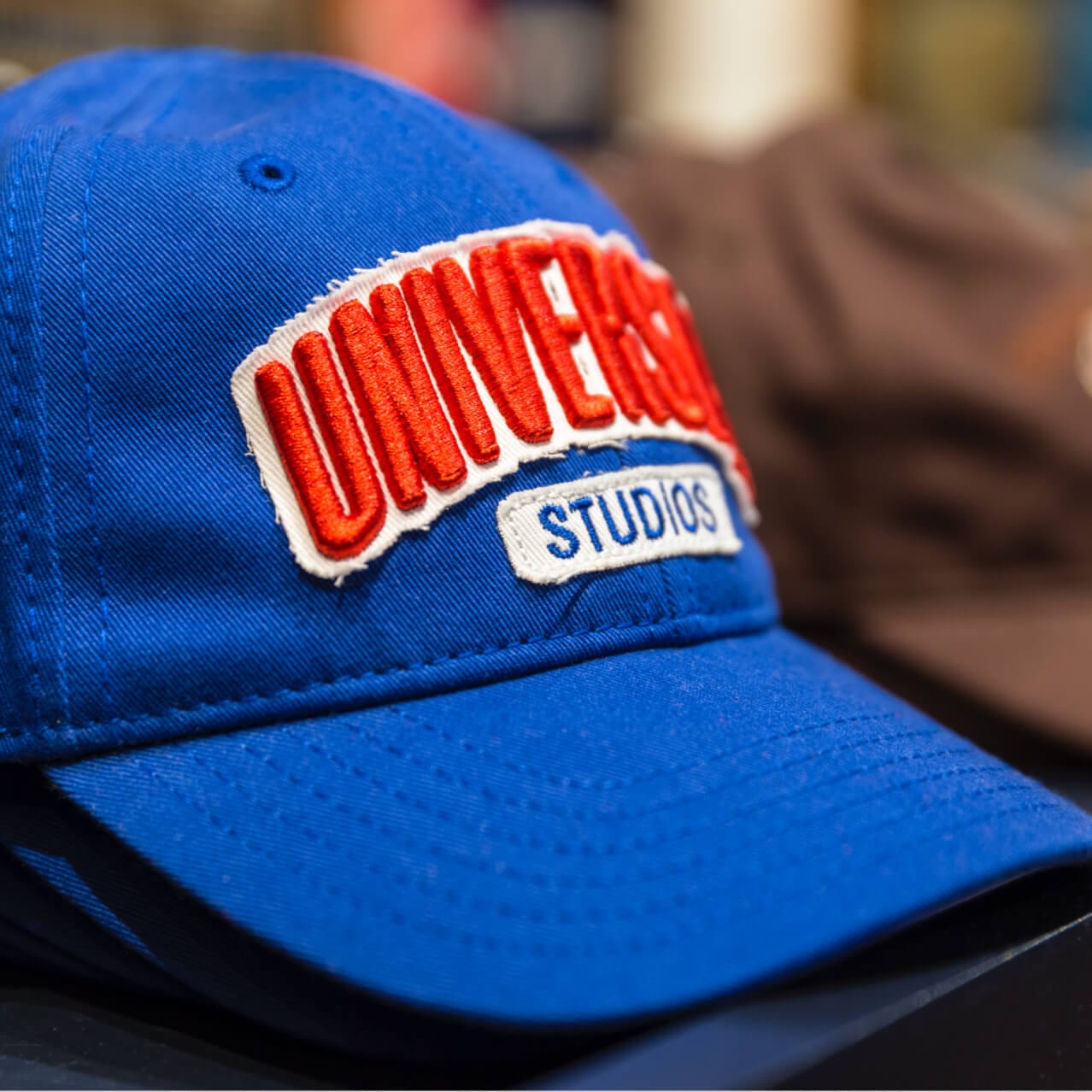 A blue and red Universal Studios hat on display inside the Universal Studios Store.