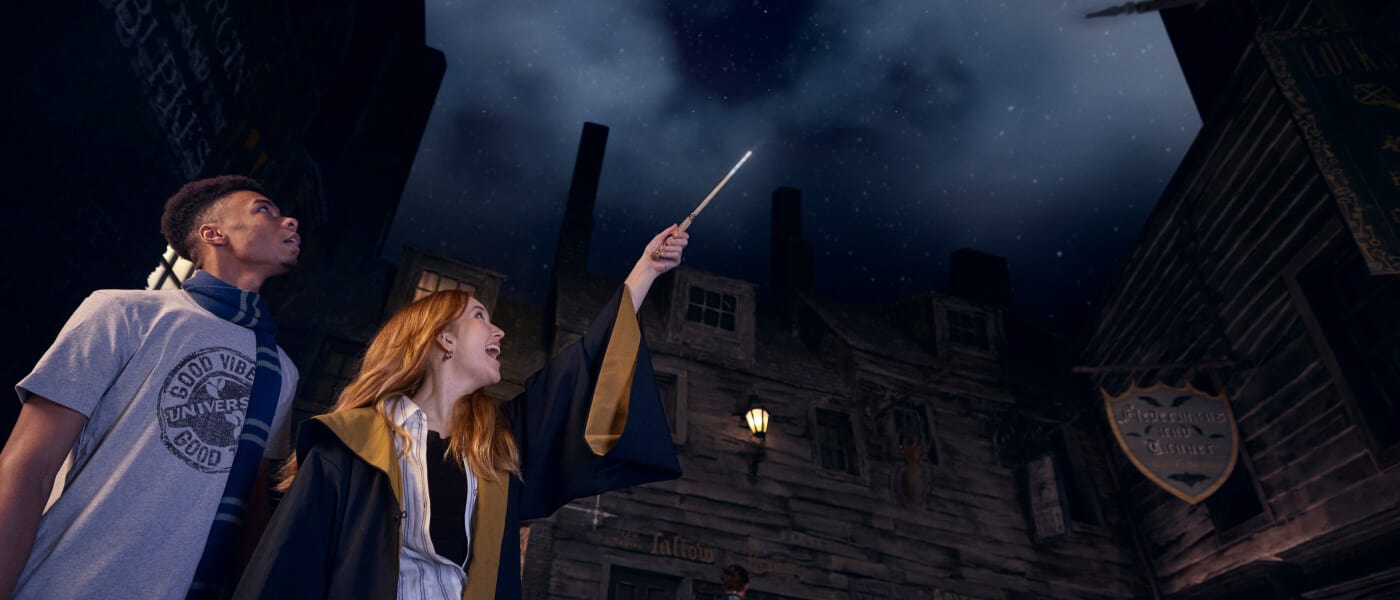 Two guests explore The Wizarding World of Harry Potter™ while using the Second Generation Interactive Wand.