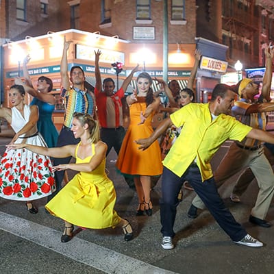A Latin dance troupe strikes a pose on the streets of Universal’s New York area.