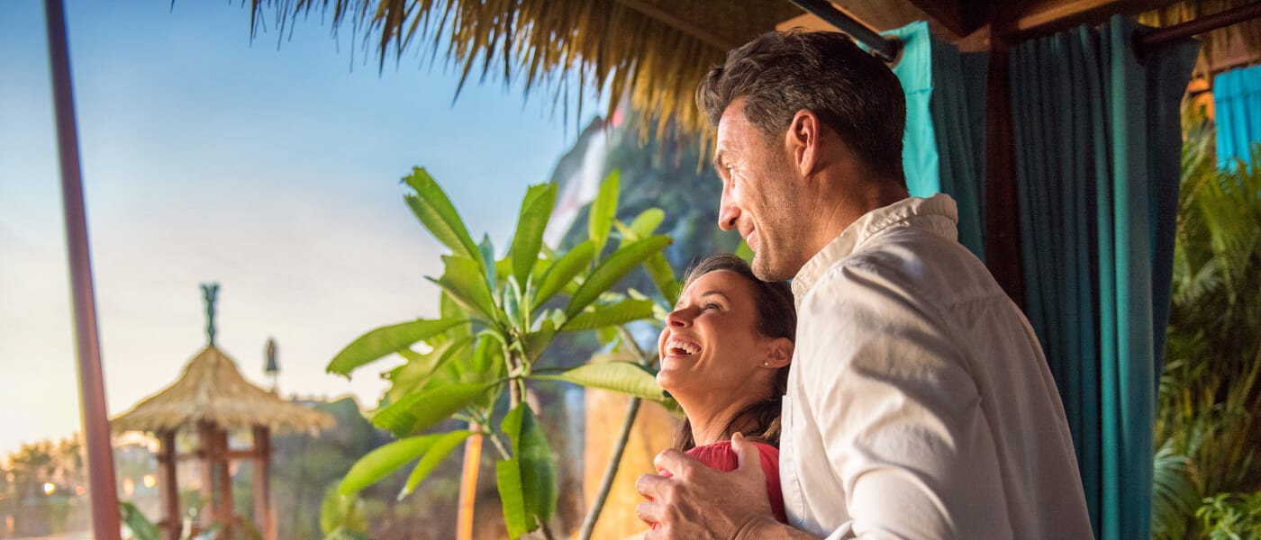 A couple looks out at Universal Volcano Bay from their private cabana.