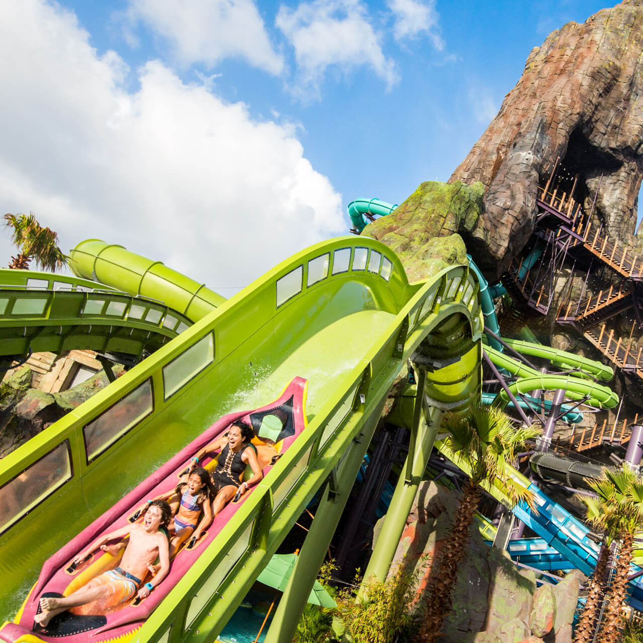 A group in a raft slides down a steep incline on the Krakatau Aqua Coaster at Universal's Volcano Bay.