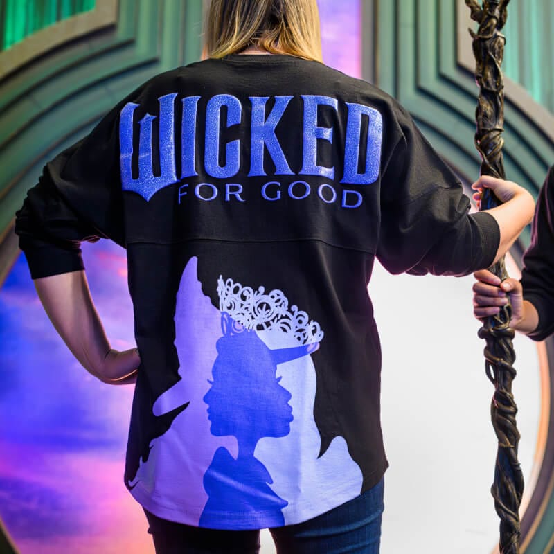 Model wearing Wicked: For Good merchandise featuring Elphaba and Glinda’s silhouettes.