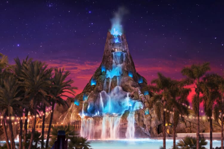 A sunset view of Krakatau illuminated with bright blue lights during Volcano Bay Nights at Universal Volcano Bay.