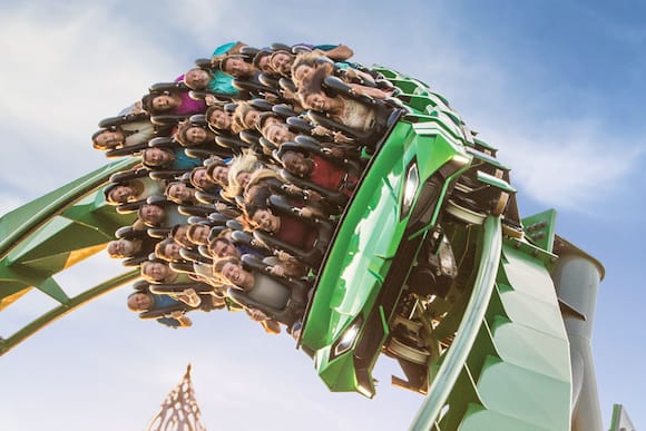 Un grupo de visitantes disfrutando The Incredible Hulk Coaster.