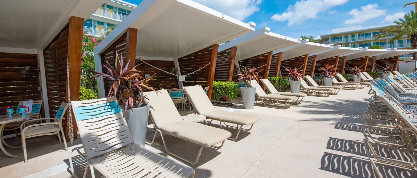 Una fila de sillones de playa y cabañas en el área de la piscina en Universal's Cabana Bay Beach Resort en Orlando.