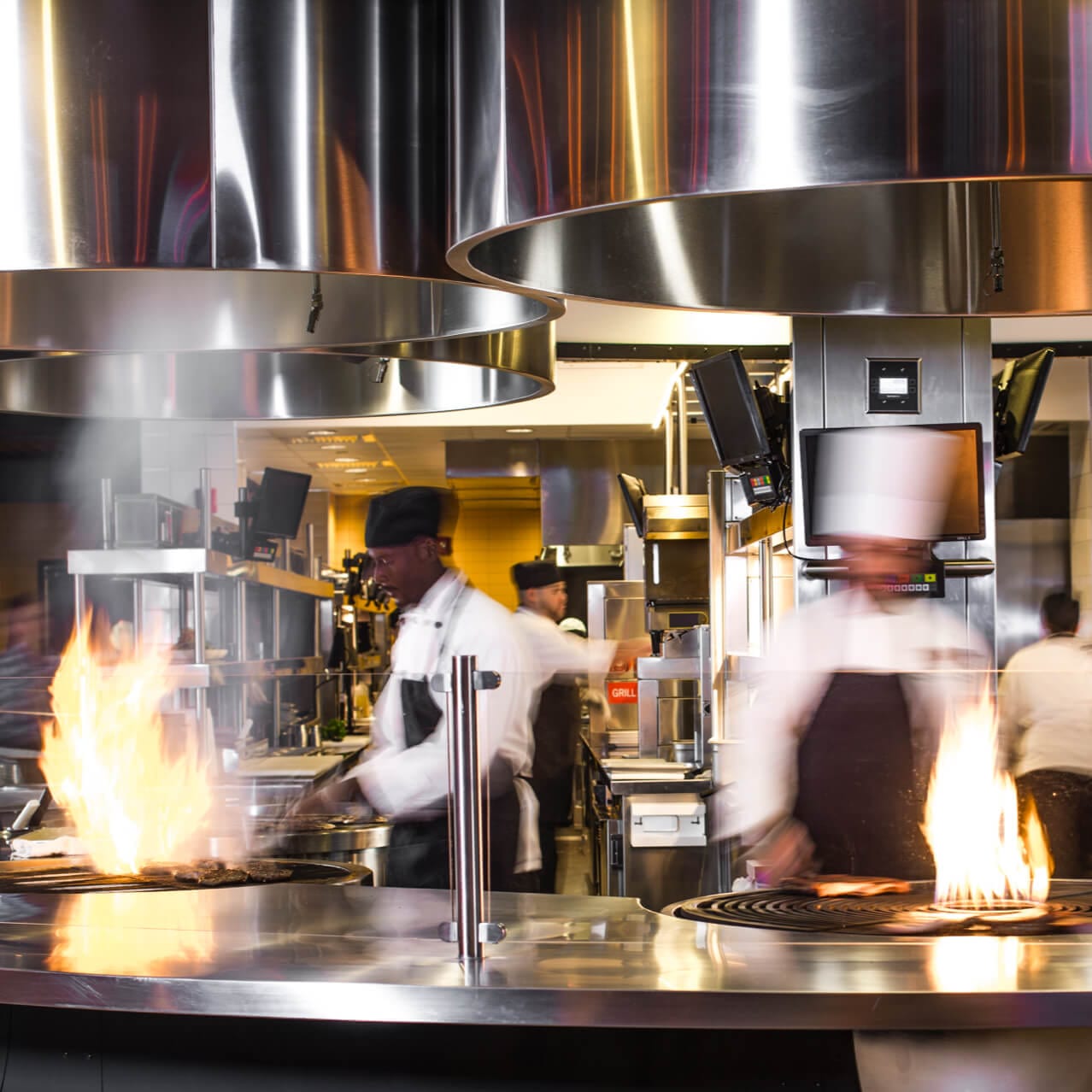 Chefs en Universal CityWalk Orlando's NBC Sports Grill And Brew cocinan platos deliciosos en la cocina abierta del restaurante.