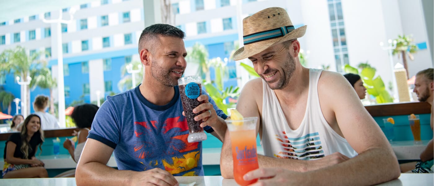 Una pareja disfruta de unas bebidas mientras se ríen en Sand Bar de Surfside Inn and Suites.