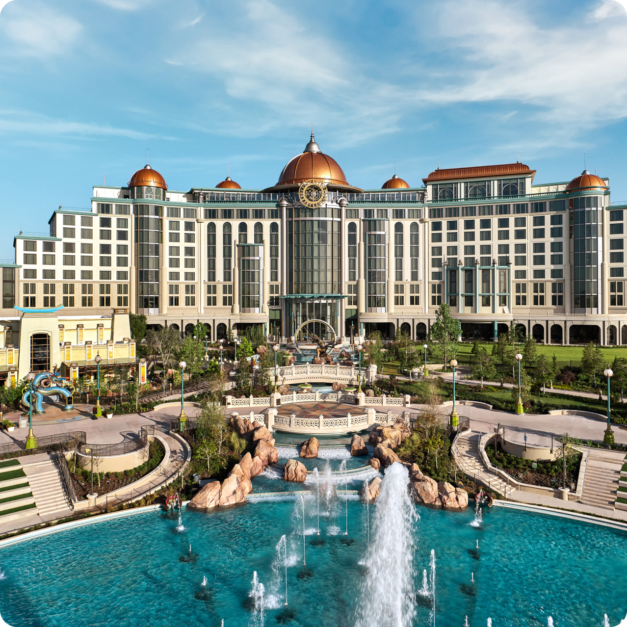 Una vista de Universal Helios Grand Hotel, un Loews Hotel, con sus torres redondas que se elevan detrás de una gran fuente de varios niveles y jardines ornamentales.