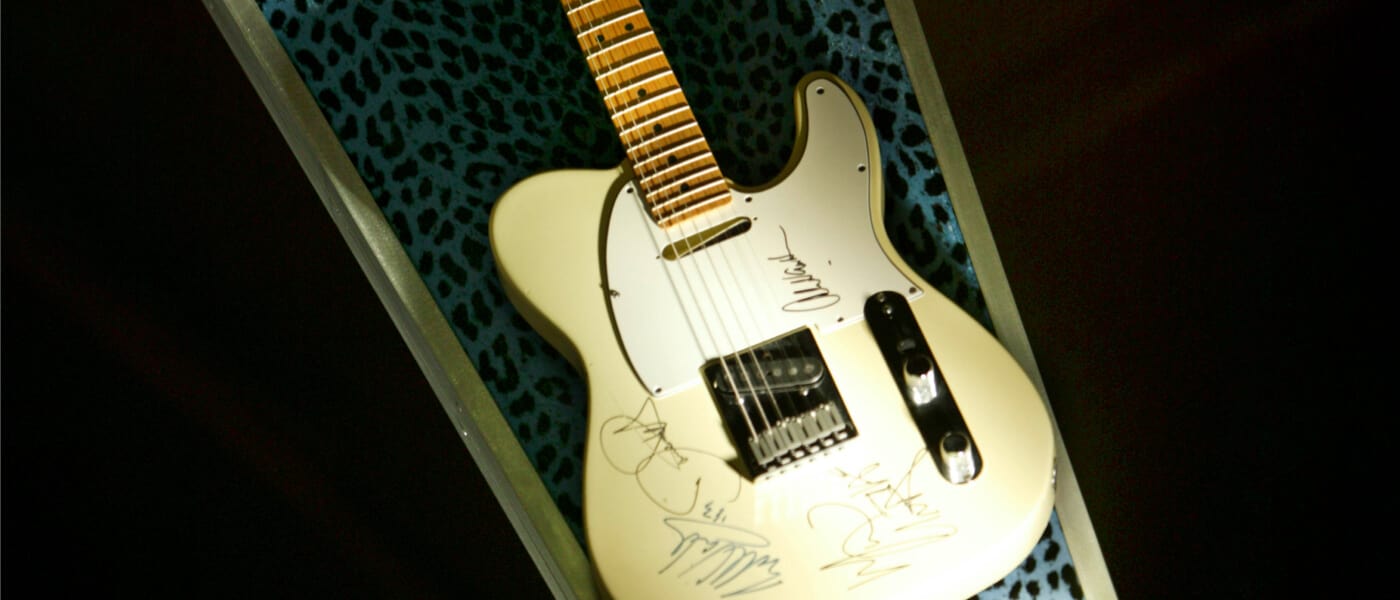 Una guitarra blanca firmada por músicos descansa en un estuche con estampado de leopardo en tonos de azul en el Hard Rock Hotel de Universal Orlando.