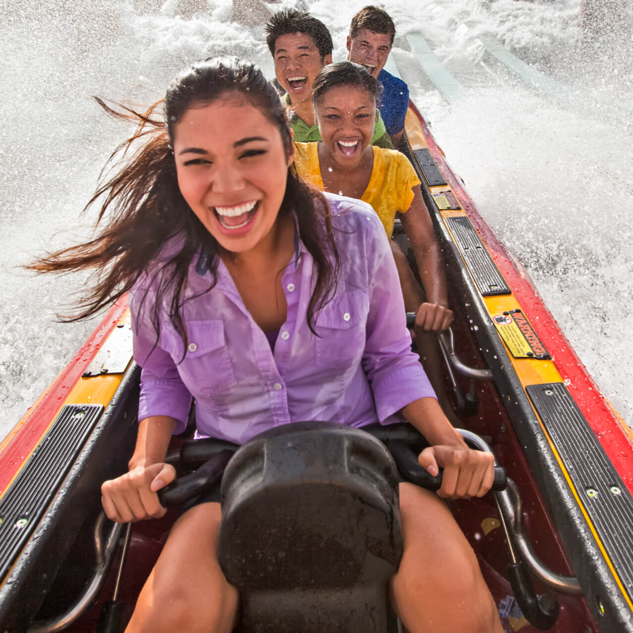 Un grupo de jóvenes salpican agua al pasar por Dudley Do Right's Ripsaw Falls en Toon Lagoon de Universal Orlando.