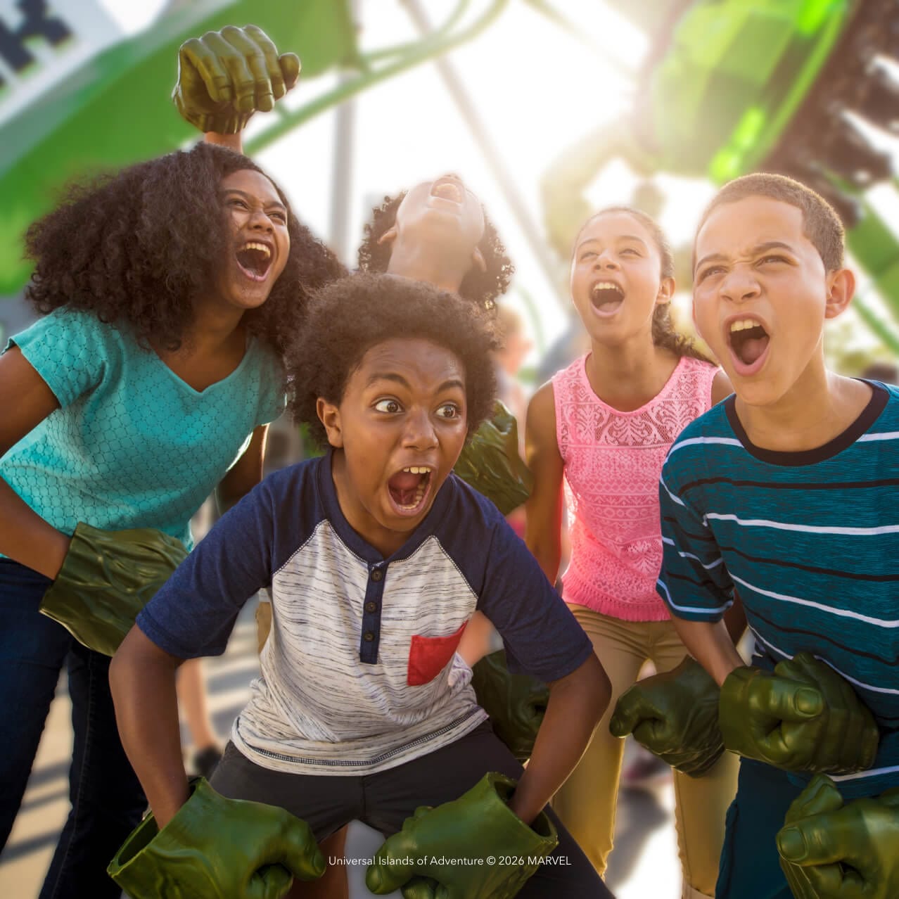 Un grupo de cinco niños jugando a ser Hulk en la entrada de The Incredible Hulk Coaster en Universal Islands of Adventure.