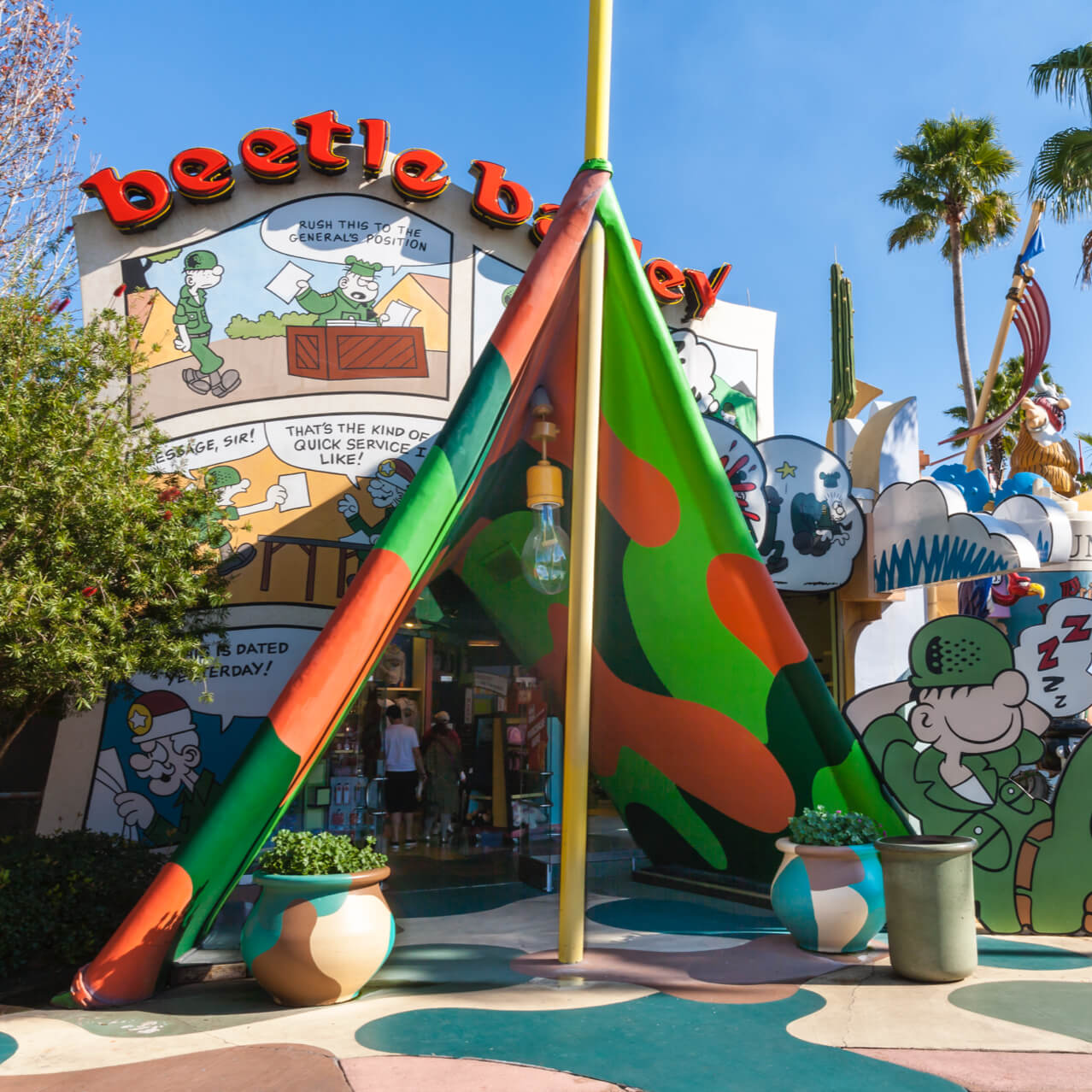 Beetle Bailey se apoya contra una enorme carpa de caricatura que sirve como entrada a la tienda Toon Extra® en Universal Orlando.