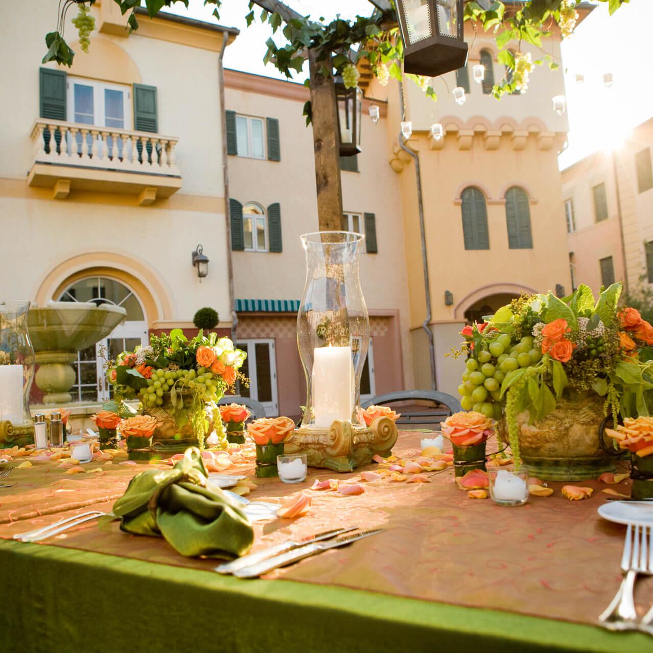 Una mesa con arreglos florales y velas dispuesta para la recepción de una boda en el Loews Portofino Bay Hotel en Universal Orlando™.