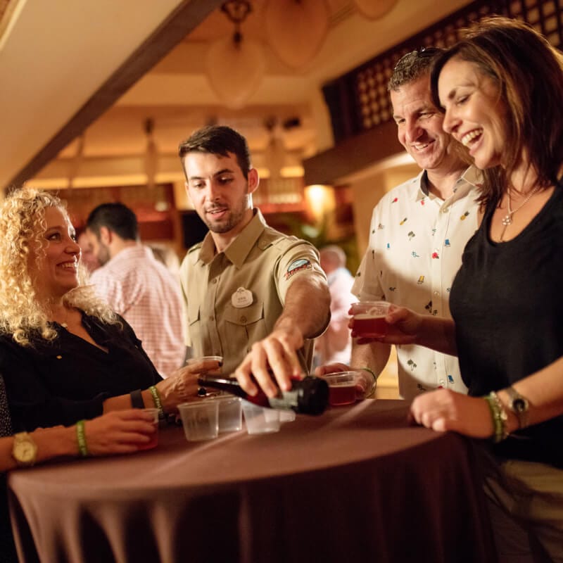 Un mesero sirve cerveza para un grupo que se reúne en una mesa durante Jake's Beer Dinner.