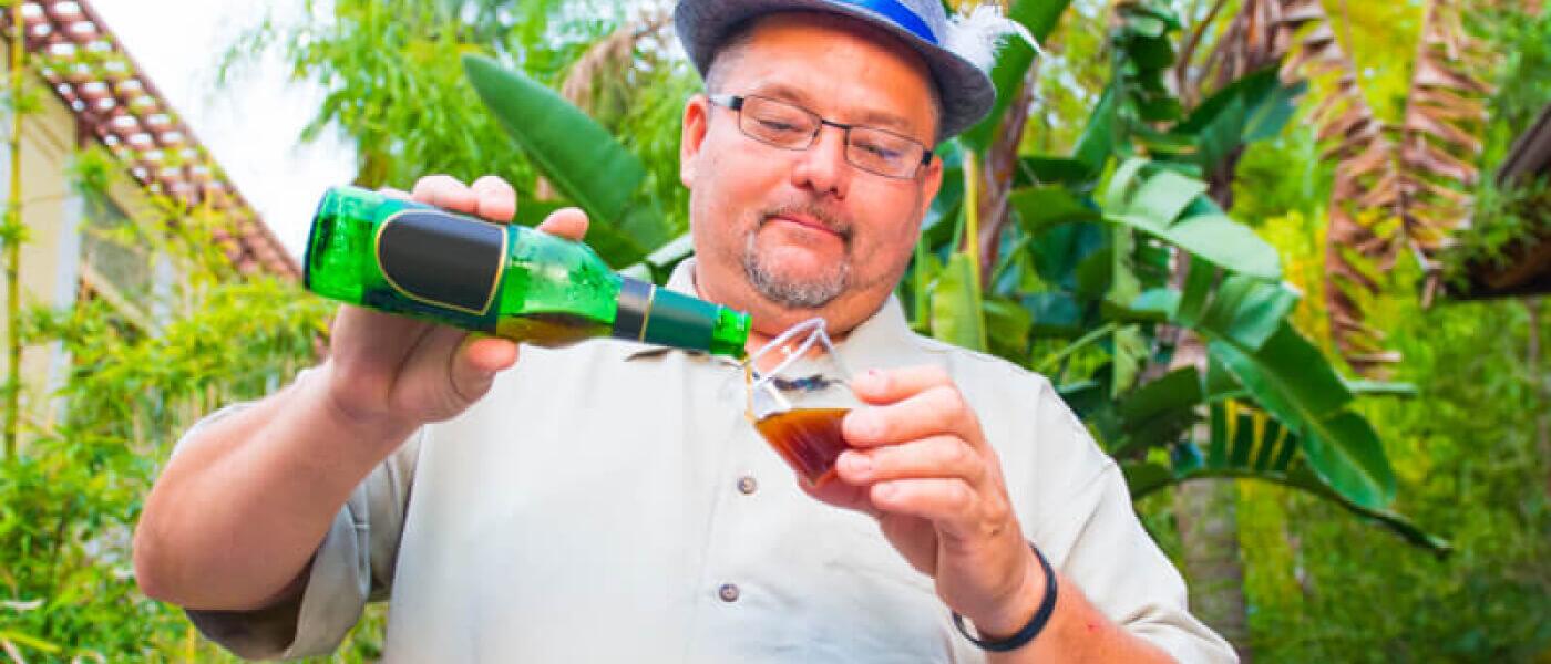 Un hombre sirve una botella de cerveza en un vaso de plástico en el evento Jake's Beer Festival, en Universal Orlando Resort.