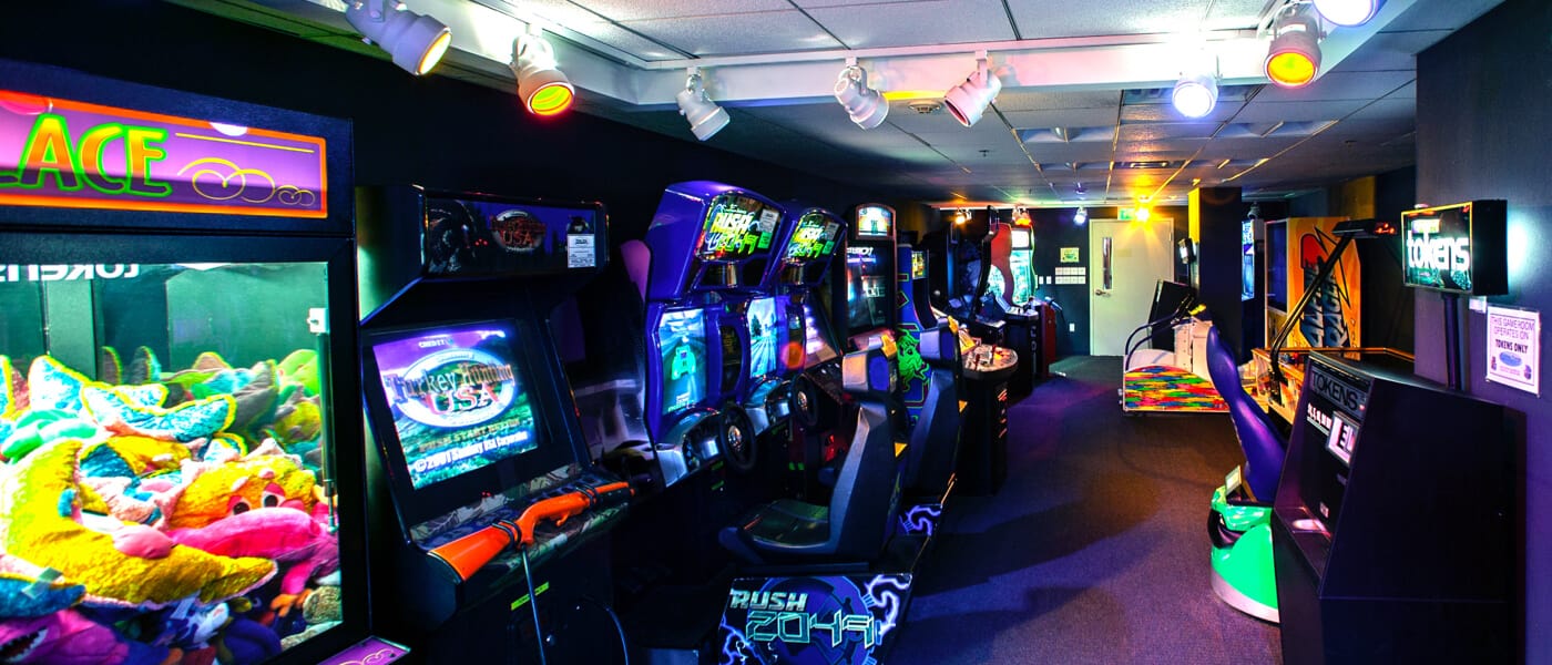 La sala de juegos del Loews Royal Pacific Resort, repleta de simuladores de carreras, una máquina de garra y otros videojuegos.