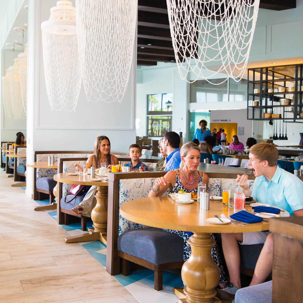 Visitantes sentados en los elegantes espacios de Amatista Cookhouse, el restaurante principal de Loews Sapphire Falls en Universal Orlando Resort.