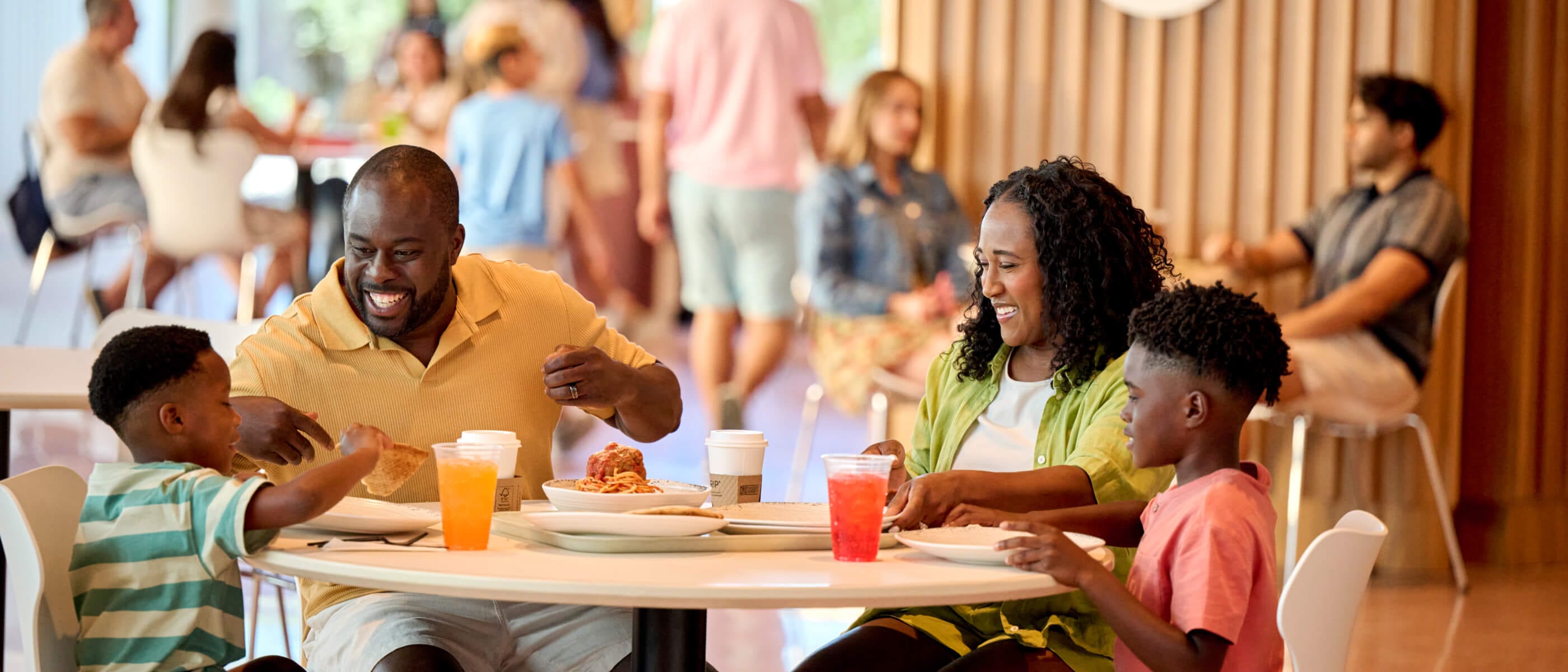 Una familia joven disfrutando de una comida en Omega Cafe and Market en Universal Terra Luna Resort.
