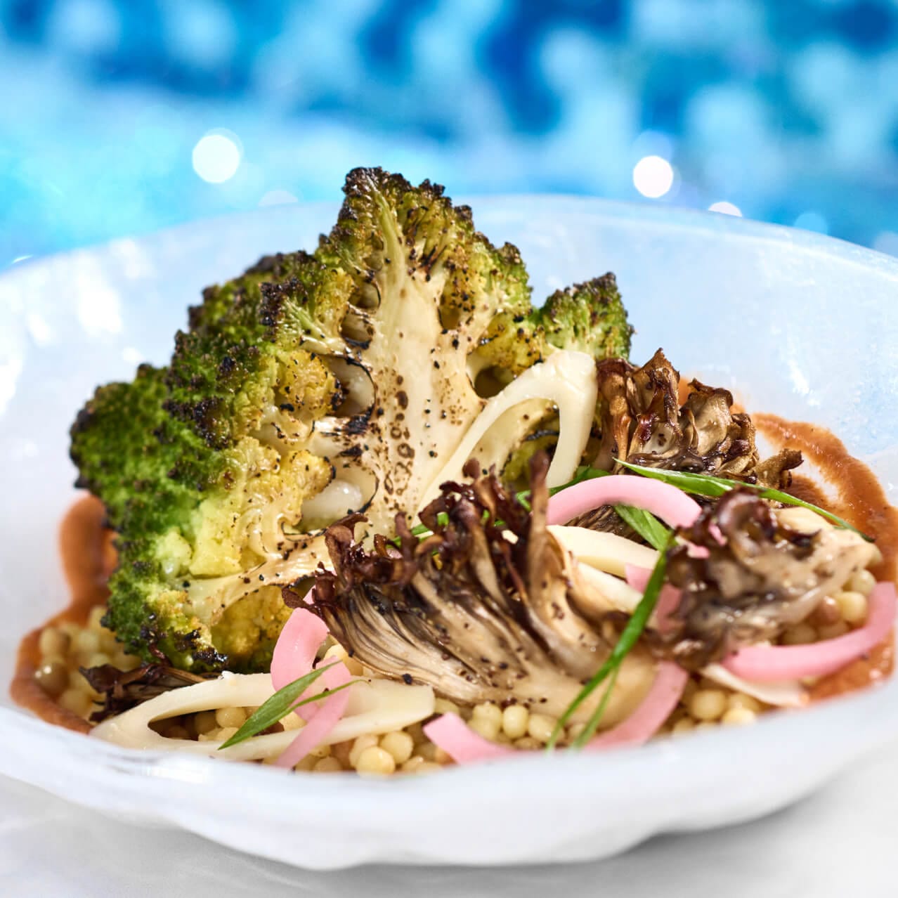 Una entrada de romanesco asado al horno con romesco de avellanas, fregola, champiñones silvestres y zarcillos de guisantes, disponible en Atlantic en Celestial Park.