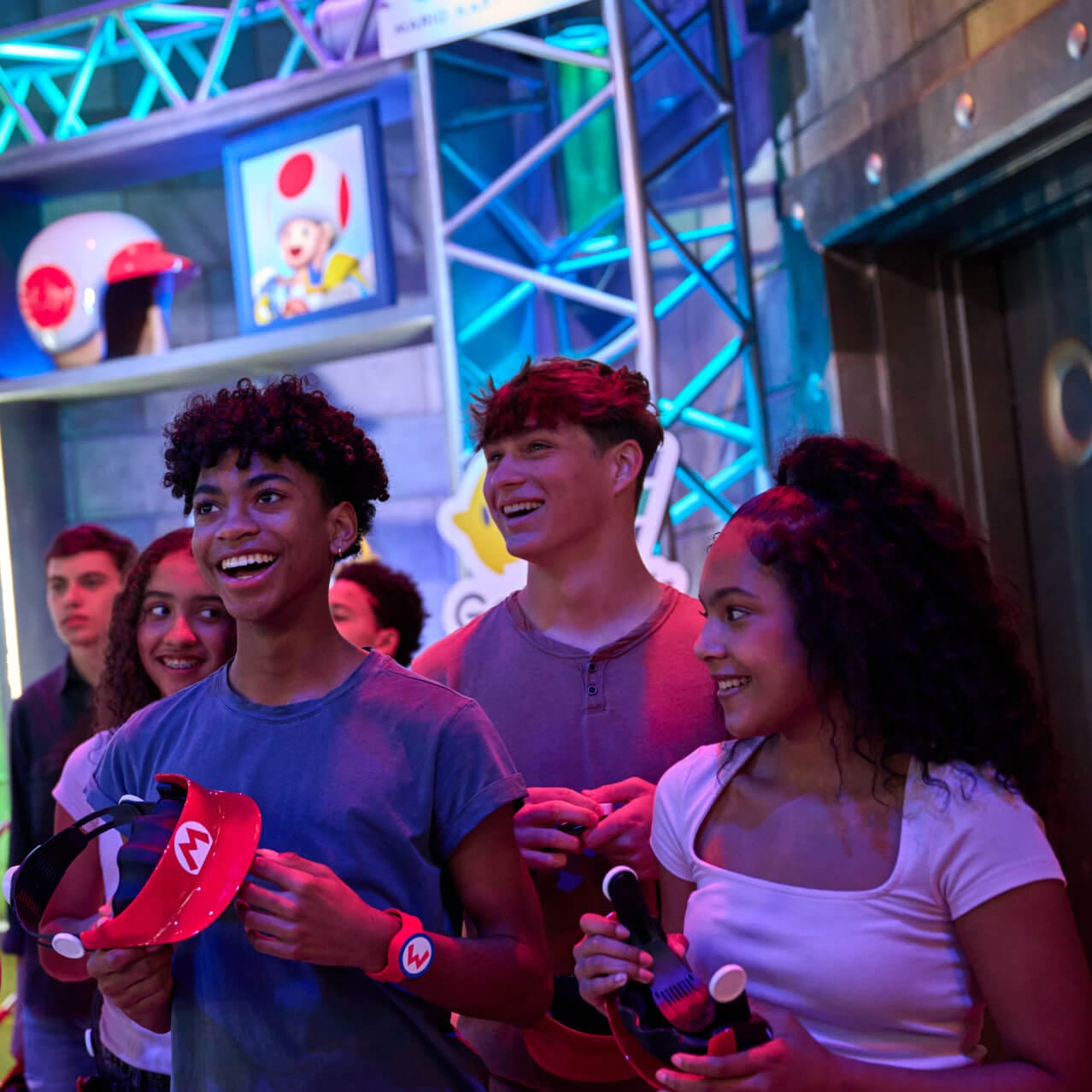 Visitantes sonrientes en la fila de Mario Kart: Bowser's Challenge en SUPER NINTENDO WORLD™ en Universal Epic Universe.