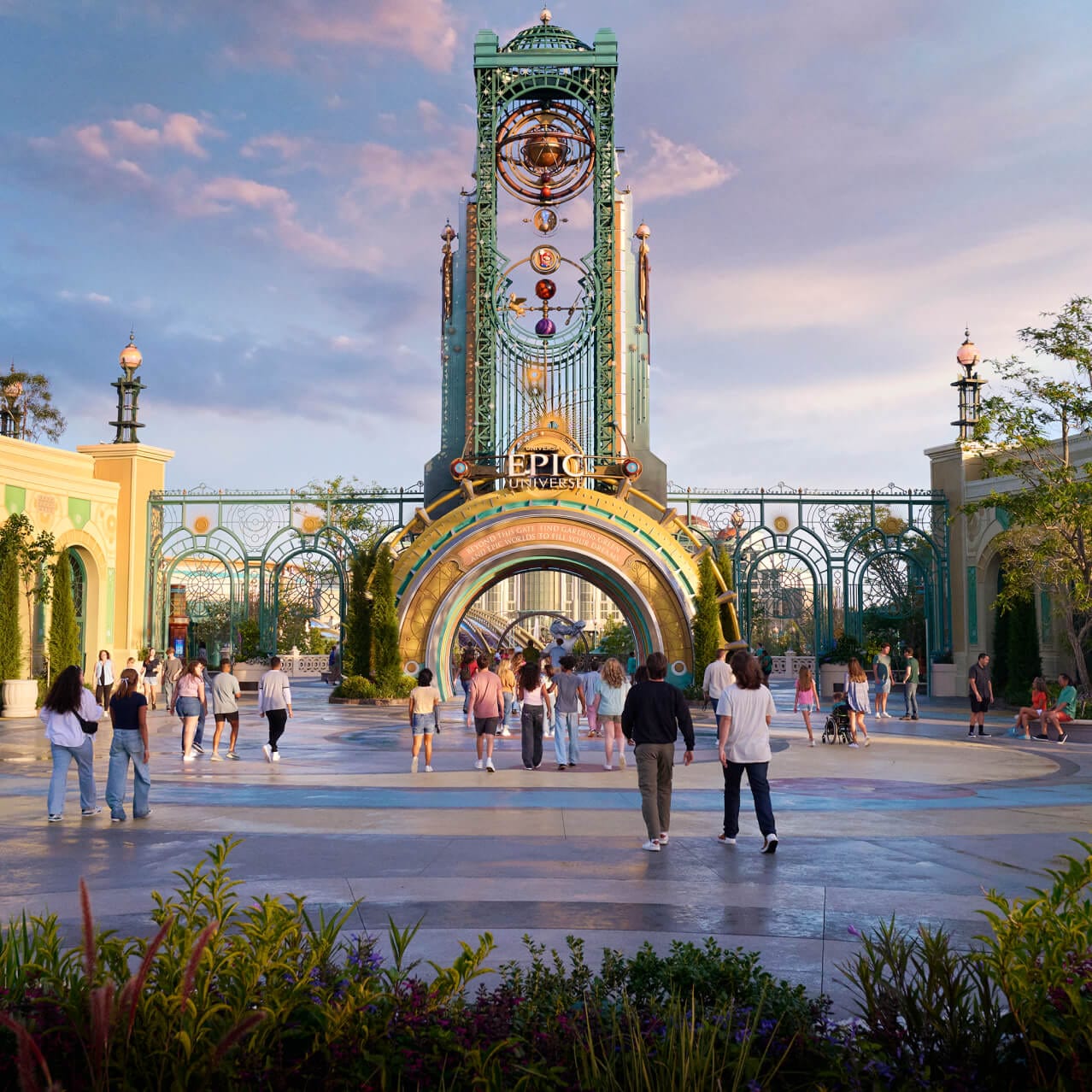 Visitantes que caminan hacia el portal de Celestial Park en la entrada principal de Universal Epic Universe, con Cronos elevándose sobre ellos.