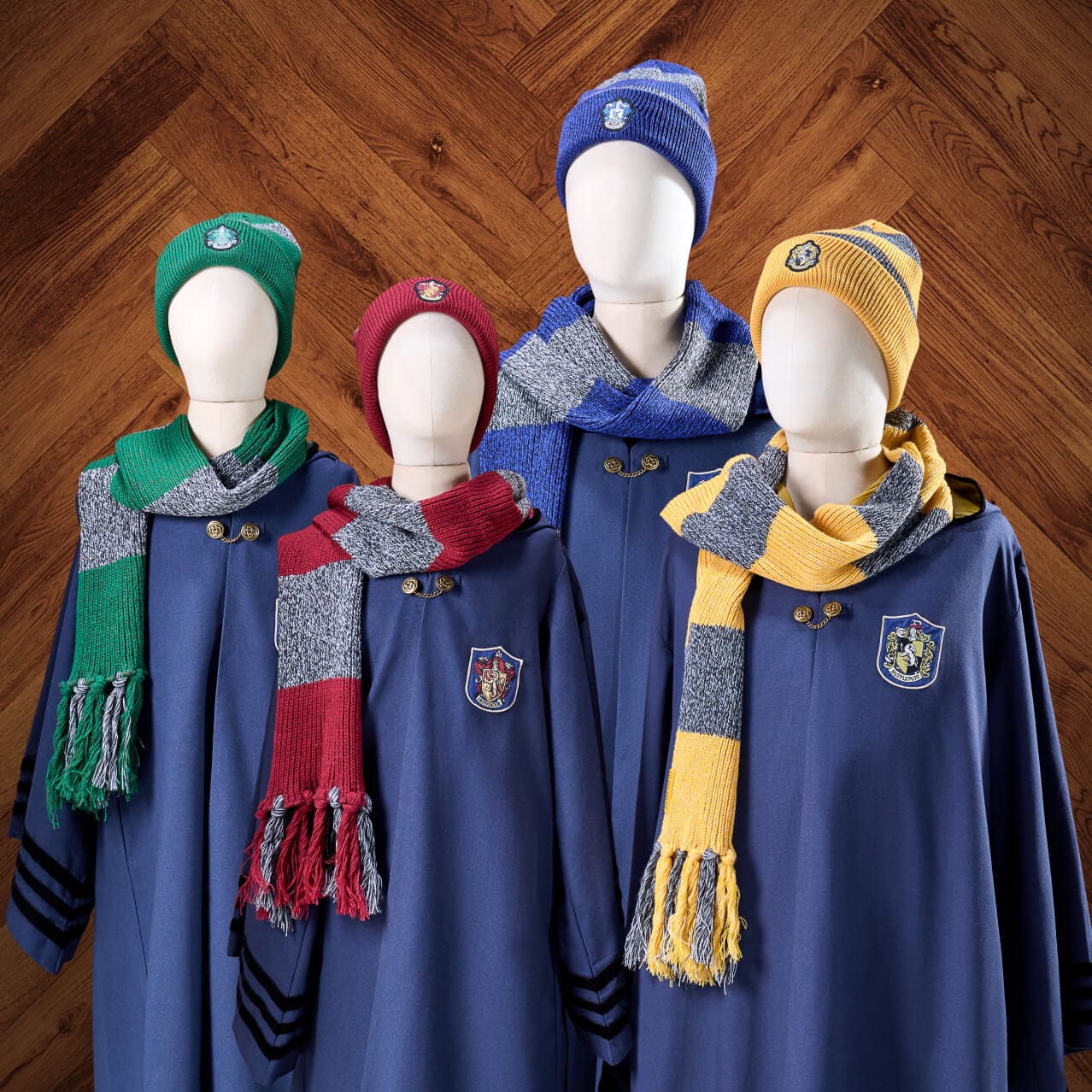 Un mostrador de túnicas, bufandas y gorros de la casa de Harry Potter de The Wizarding World of Harry Potter™ — Ministry of Magic™ en Universal Epic Universe.