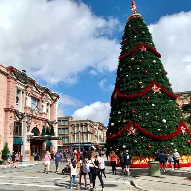 Calle inspirada en la Ciudad de Nueva York en Universal Studios Florida con edificios decorados de manera festiva y un gran árbol de Navidad.