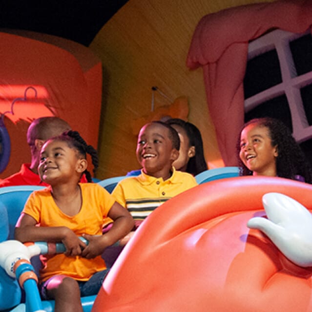 Niños emocionados a bordo de The Cat and the Hat dentro de Seuss Landing en Universal Islands of Adventure