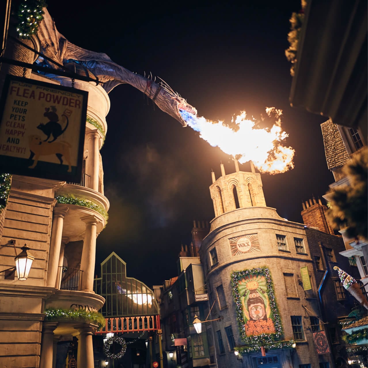 El dragón sobre Gringotts™ lanza fuego sobre Diagon Alley™, que está festivamente decorado para la época festiva en Universal.